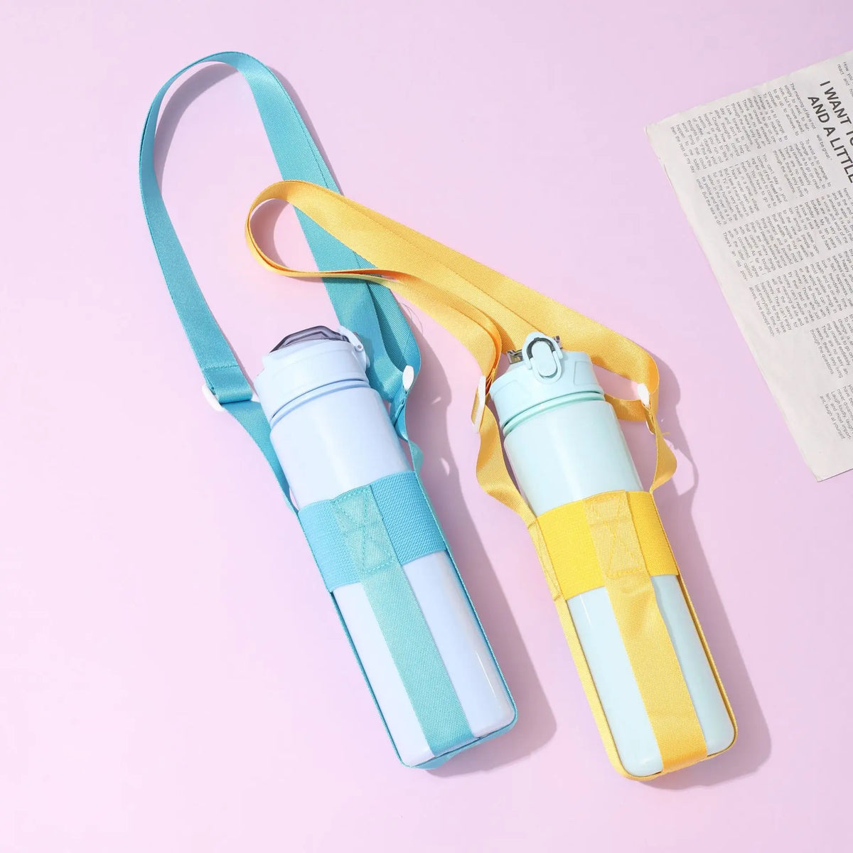 A light blue and yellow crossbody sling water bottle bag with a white strap is displayed on a pink background.