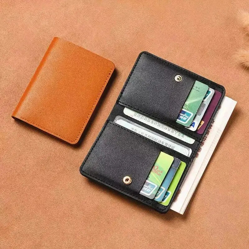 A brown classic PU leather small wallet with a black sleeve holding several cards on a tan background.