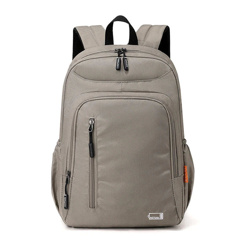A gray fashion commuter daypack for women with black straps and zippers.