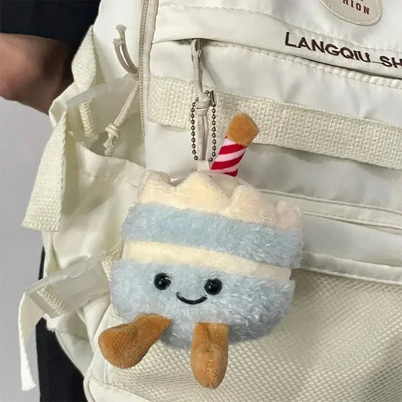 A fluffy blue and white bread plush keychain hanging from a zipper pull on a light-colored bag.