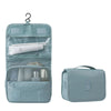 Helles blaues tragbares Reise-Toilettenorganizer mit mehreren Fächern und einer separaten Reißverschlusstasche.