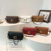 A display of women's premium textured shoulder bags in brown, cream, and burgundy leather.