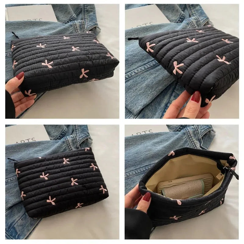 Black quilted makeup pouch with pink embroidery shown in various angles against a denim background.
