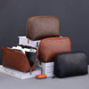 A set of brown and black leather multi-layer cable organizer pouches displayed on a gray surface.