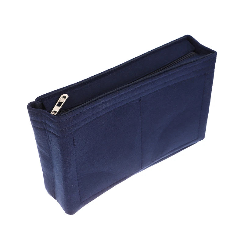 A navy blue felt cosmetic bag insert organizer with a zippered compartment.