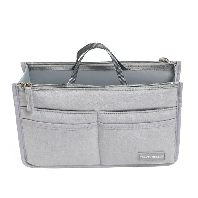 A light gray handbag organizer insert with a zipper and two internal pockets.