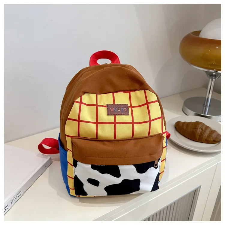 A brown and yellow patterned backpack with a cow print fabric detail resting on a white surface.