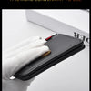 A hand holds a black lightweight and thin credit card wallet against a white background.