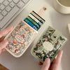 A hand holds a rectangular PU card wallet with floral design and a leather strap, featuring several cards.