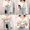 A woman models a white long-sleeved shirt and jeans while holding a black phone attached to a colorful lanyard with a teal le