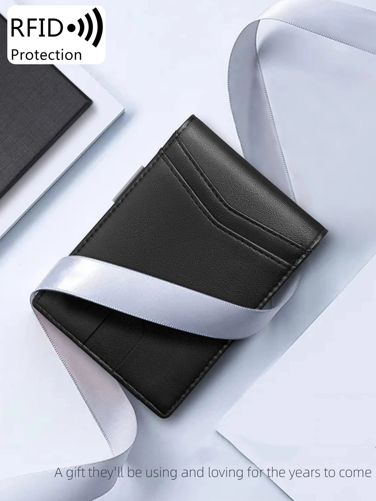 A black and silver minimalist slim wallet is shown against a white background.