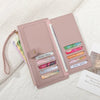 A pink PU leather coin purse and card holder with multiple slots for cards and coins, resting on a white textured fabric.