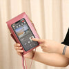 A hand holds a pink women's touch screen crossbody shoulder bag displaying a smartphone screen.