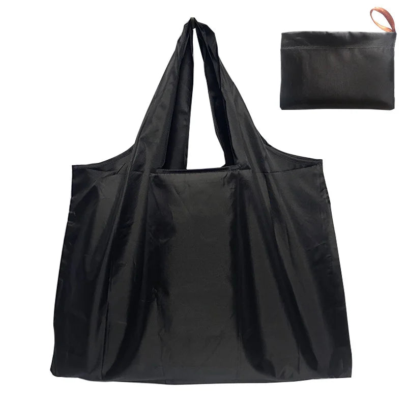 A black canvas tote shopping bag with a drawstring closure is shown against a white background.