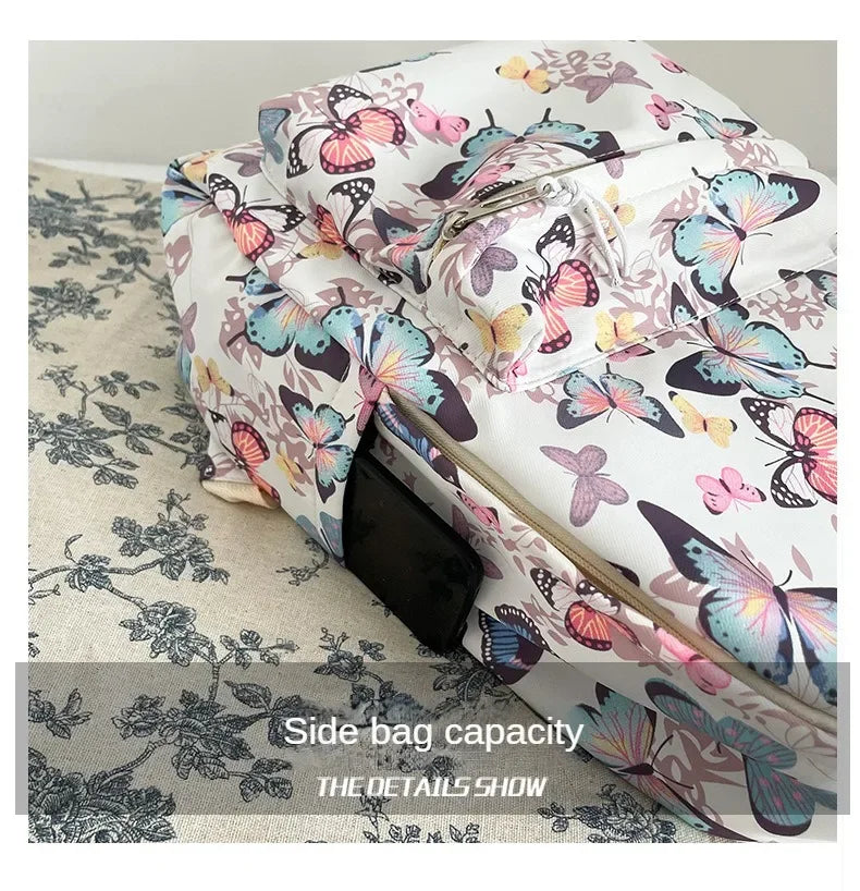 A side view of a white backpack featuring a colorful butterfly pattern on the fabric.