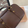 A brown vintage PU leather shoulder bag is shown in a close-up view resting on a white surface.