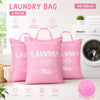 Three pink laundry bags are displayed next to a washing machine, showing various uses like clothes, shoes, toys, and bedding.