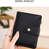 A hand holds a black RFID blocking bi-fold card holder wallet displaying its texture and closure.
