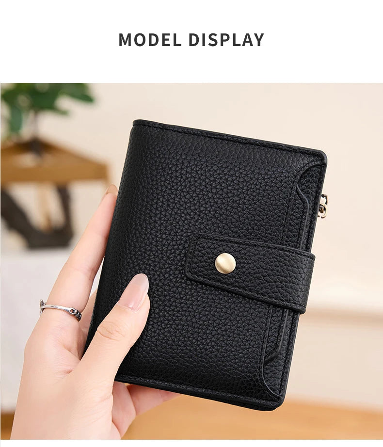 A hand holds a black RFID blocking bi-fold card holder wallet displaying its texture and closure.