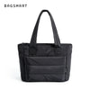 Sac fourre-tout matelassé noir à capuche avec une sangle d'épaule, sur fond blanc.
