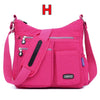 Helle pinke wasserdichte Nylon-Crossbodytasche mit schwarzem Riemen und Reißverschlusstaschen.