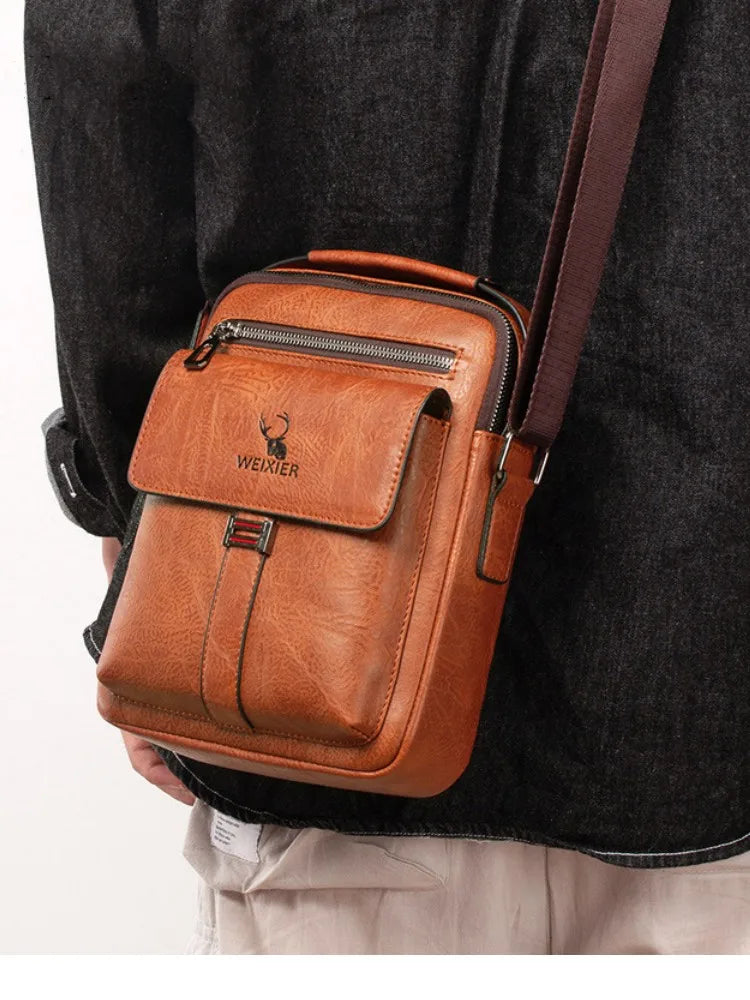 A brown vintage PU leather crossbody messenger bag with a dark brown strap worn by a person.