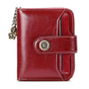 A deep red leather wallet with a brass clasp and card slots shown from the front.
