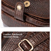 Detail display showing a magnetic snap closure and a leather patchwork shoulder strap on a brown leather bag.