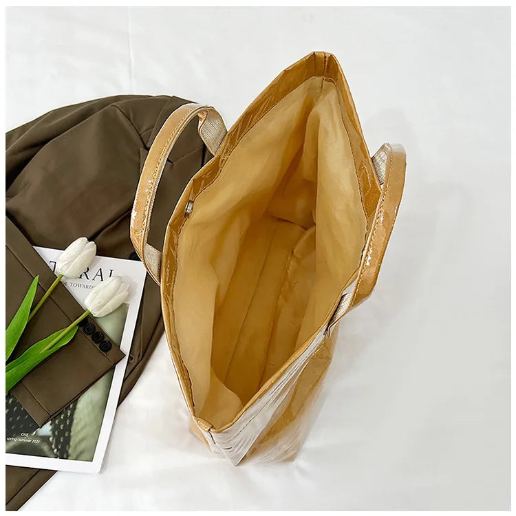 A light brown transparent waterproof PVC tote bag is shown with its interior lining visible.