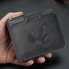 A dark gray embossed PU leather slim wallet with a bird design is held in a hand.