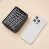 A black crocodile print fashion PU leather double zipper wallet placed next to a white smartphone.