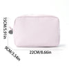 A pink seersucker striped cosmetic bag with a zipper closure shown flat.