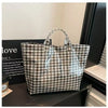 A transparent waterproof PVC tote bag with a black and white checkered pattern displayed on a dark surface.