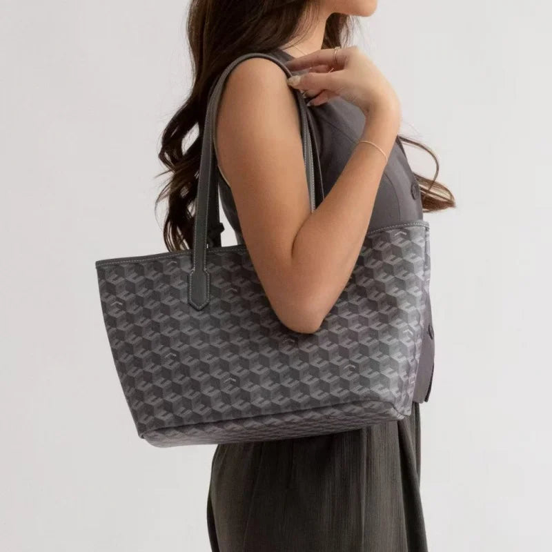 A woman holds a gray geometric patterned tote bag against a light background.