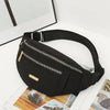 Black multi-layer sports waist bag with a zipper and strap resting on a white surface.