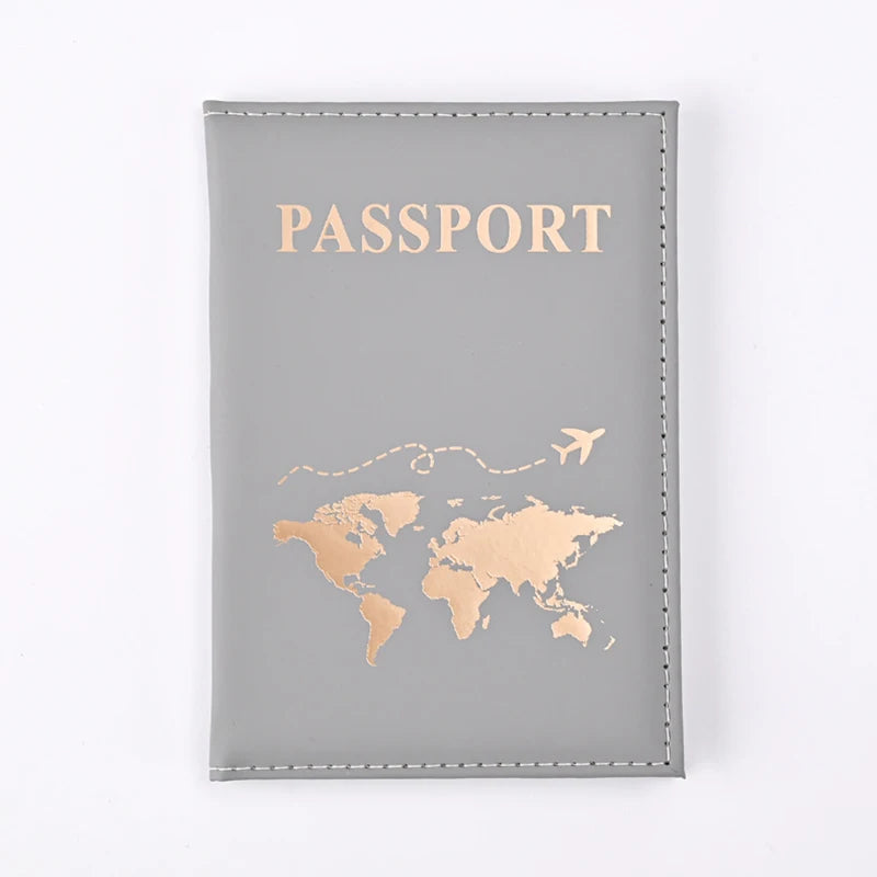 A grey leather passport holder with gold foil printing of the world map and the word PASSPORT.