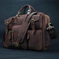 A brown genuine leather briefcase with multiple compartments and a shoulder strap is shown against a dark background.