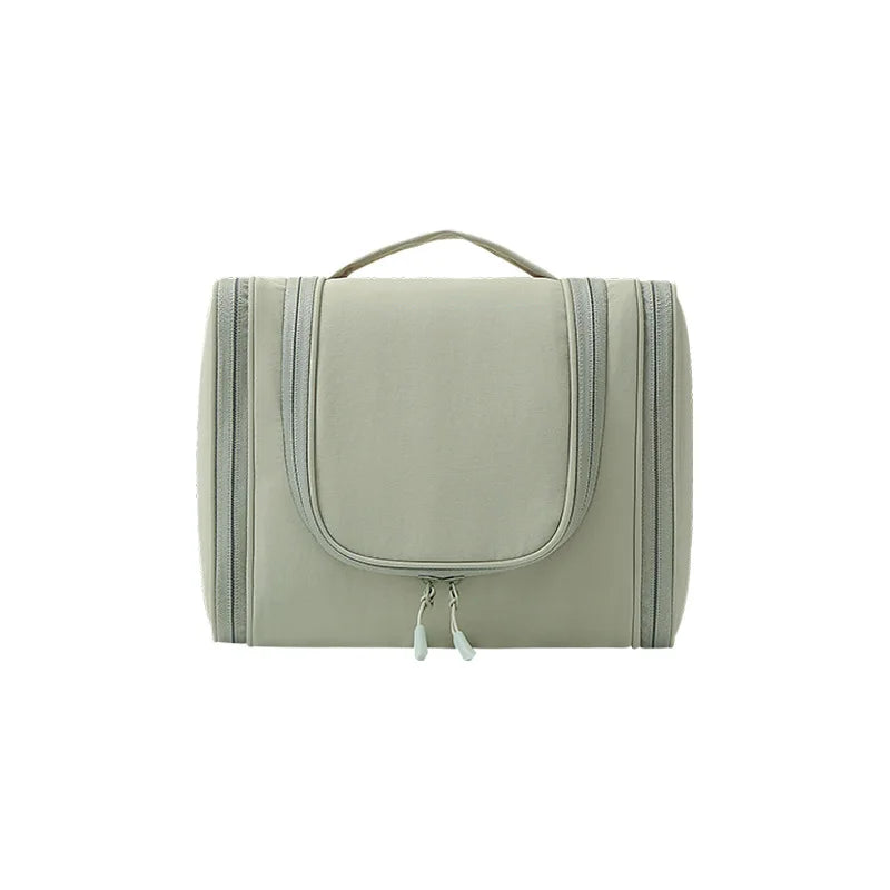 A light sage green waterproof hanging toiletry bag with a handle and zipper.