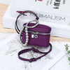 A purple leather coin purse with a silver chain and lanyard is displayed on a map background.