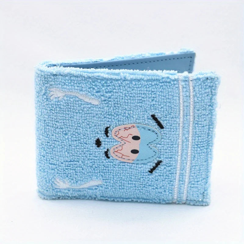 Light blue embroidered fabric wallet with a stitched design on the front