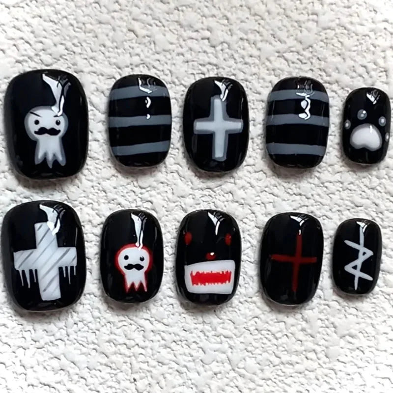 A set of press-on nails featuring various cartoon and gothic designs on black and white tips.