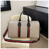 A women's plaid travel duffle bag in beige and green fabric resting on a white chair.