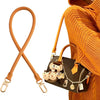 A brown leather replacement shoulder strap is shown against an orange knitted sweater, next to a black handbag.