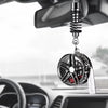 A black alloy wheel hub brake disc pendant hangs from a chain and is positioned in front of a car's rearview mirror.
