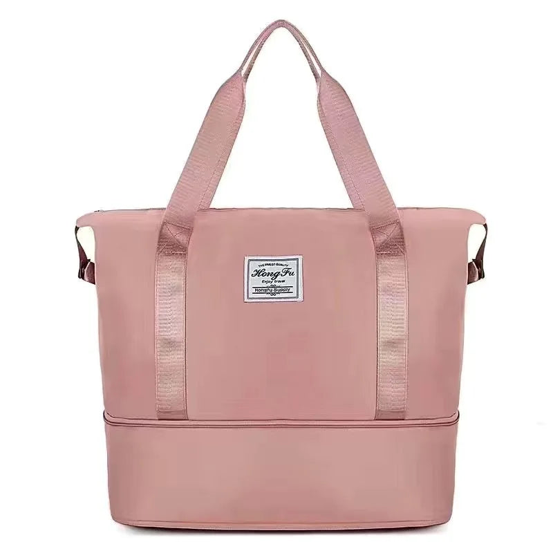 A pink expandable travel organizer bag with two handles shown against a white background.