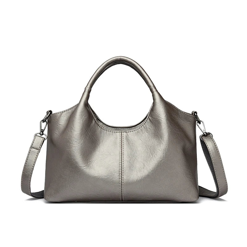 A smooth, taupe-gray leather women's casual crossbody shoulder bag with a top handle.