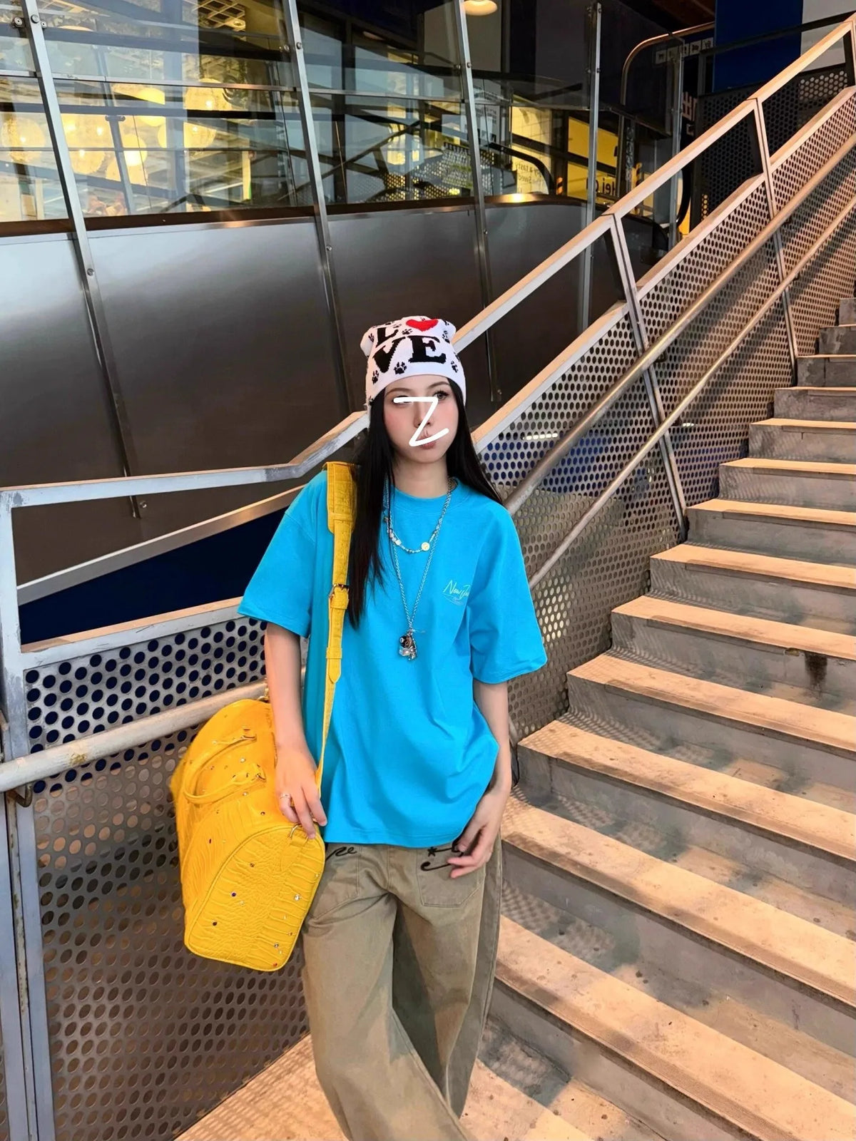 A person wearing a blue t-shirt and a patterned headband is walking down an outdoor metal staircase.