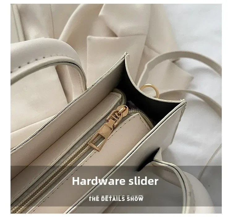 Gros plan d'un sac à main en cuir PU beige minimaliste montrant le détail du coulisseuse en métal doré.