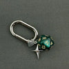 A silver keychain featuring a green resin die with the number 13 and a star charm.