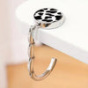 A round metal bag hanger with a black and white leopard print top and a silver chain.